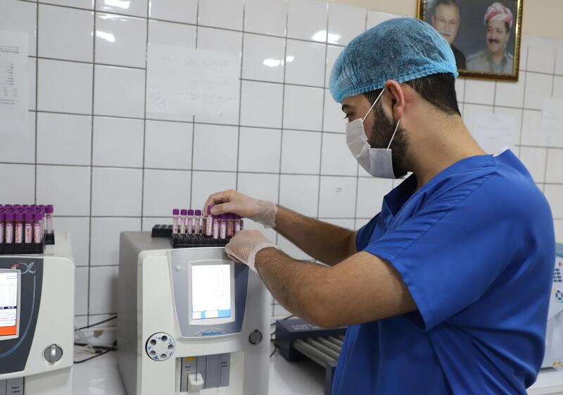 An Iraqi Kurdish medical worker tests samples for Covid-19 at a hospital in the northeastern city of Sulaymaniyah in Iraq's autonomous Kurdistan region, which has seen the hights death rates from the novel coronavirus. The virus has hit hard Iraq which more than 375,000 people infected and some 9,500 deaths.  AFP