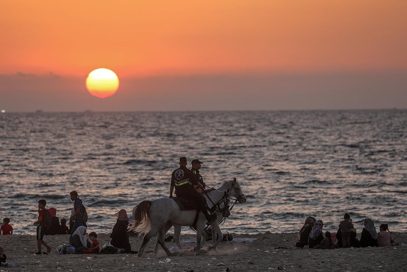 Palestinian families enjoy their time at the beach amid the ongoing Covid-19 pandemic in Gaza City.  EPA