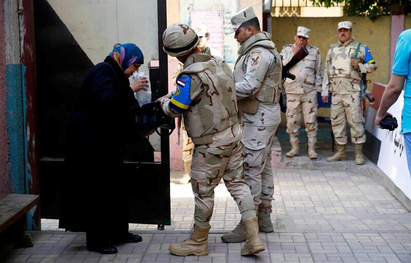 An Egyptian soldier searches a woman purse as she arrives to cast her vote during the presidential election in Cairo, Egypt. Amr Abdallah Dalsh / Reuters