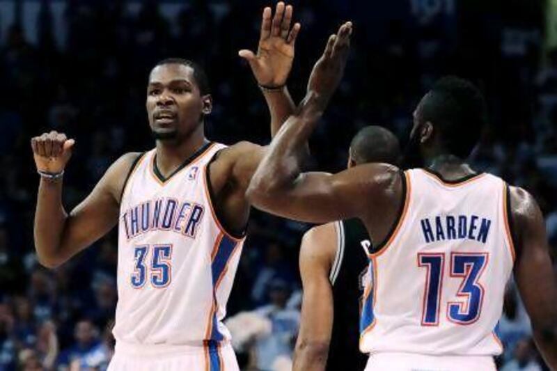 Kevin Durant, left, celebrates with teammate James Harden in Oklahoma City's 109-103 series-evening win.