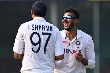 India's Axar Patel (R) celebrates with teammate Ishant Sharma after taking the wicket of New Zealand's Tim Southee (not pictured) on the third day of the first Test cricket match between India and New Zealand at the Green Park Stadium in Kanpur on November 27, 2021.  (Photo by Sajjad HUSSAIN  /  AFP)  /  IMAGE RESTRICTED TO EDITORIAL USE - STRICTLY NO COMMERCIAL USE