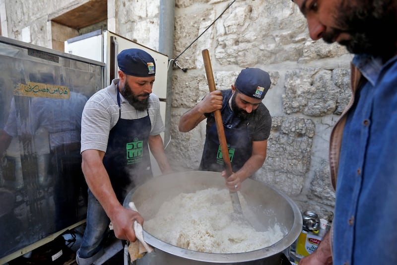 Volunteers stir a pot of rice for a charity iftar at the eighth century Umayyad Mosque in Syria's capital Damascus. AFP