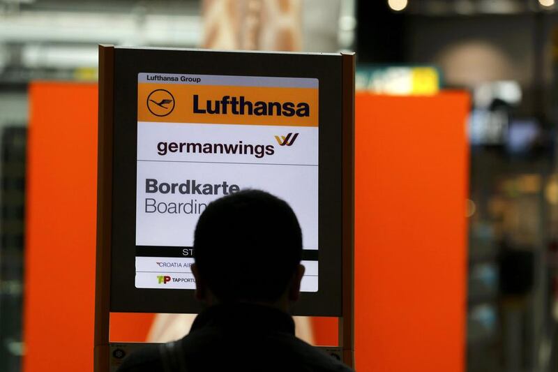 A passenger stands in front of a German airlines Lufthansa and Germanwings sign at Duesseldorf airport. Wolfgang Rattay / Reuters