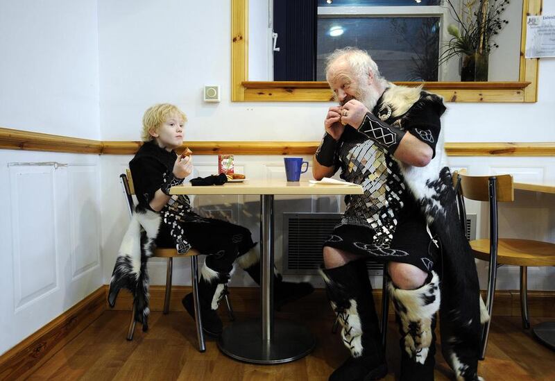 A man and a boy dressed as Vikings eat breakfast, as you know, being a Viking for the day requires a full stomach. Andy Buchanan / AFP Photo