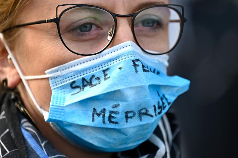 A health worker wearing a protective mask reading "midwife scorned" demonstrates in Rennes. AFP