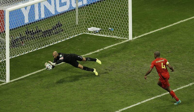 US goalkeeper Tim Howard makes a save on Vincent Kompany of Belgium on Tuesday in their match at the 3014 World Cup. Themba Hadebe / AP