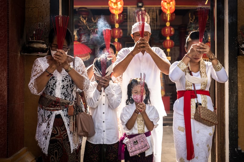 Members of a Balinese Chinese family wearing Balinese attire pray at the Vihara Dharmayana Kuta temple. Getty Images
