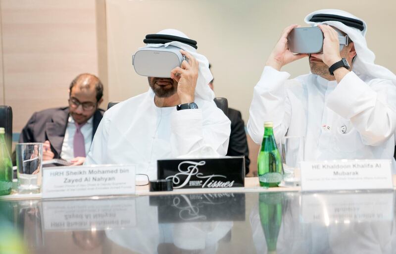 SINGAPORE, SINGAPORE - February 28, 2019: HH Sheikh Mohamed bin Zayed Al Nahyan, Crown Prince of Abu Dhabi and Deputy Supreme Commander of the UAE Armed Forces (L), looks through a virtual reality goggles, during a meeting, at Mubadala's GLOBALFOUNDRIES semiconductor facility. Seen with HE Khaldoon Khalifa Al Mubarak, CEO and Managing Director Mubadala, Chairman of the Abu Dhabi Executive Affairs Authority and Abu Dhabi Executive Council Member (R).

( Eissa Al Hammadi for the Ministry of Presidential Affairs )
---
