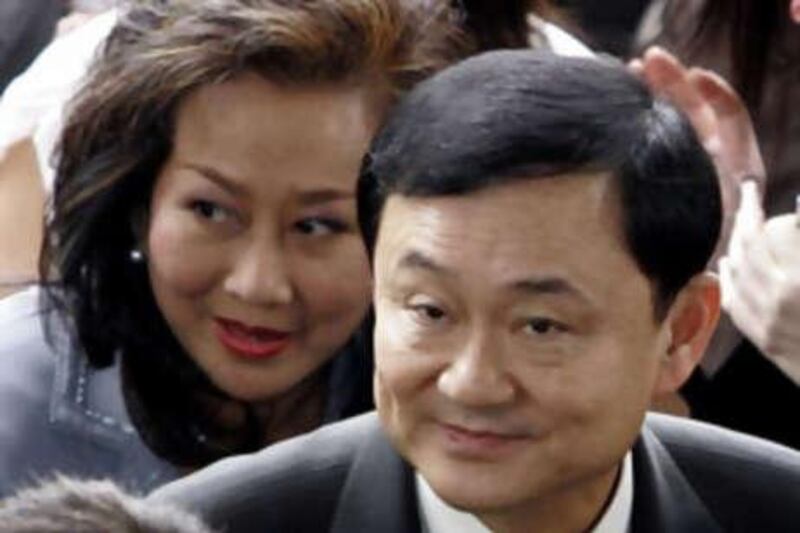 Thaksin Shinawatra and his wife Pojaman arriving at criminal court in Bangkok last month. He and his wife failed to report before a high court today.
