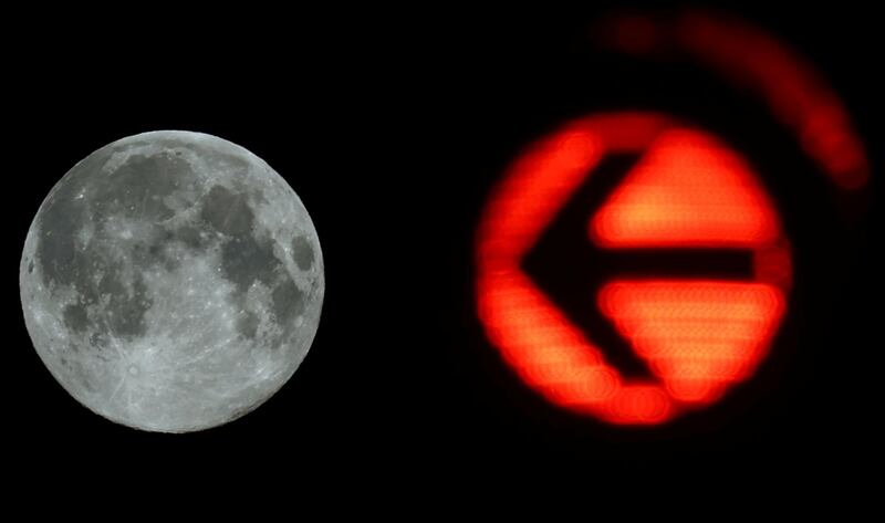 It's right there: A traffic light points the way to the supermoon in Frankfurt, Germany. Reuters