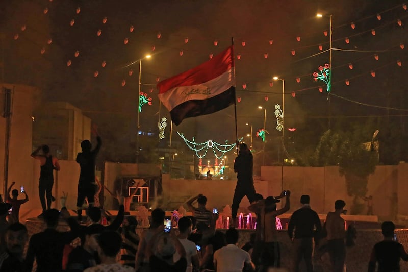 An Iraqi protester waves the national flag during an anti-government demonstration in the Shiite shrine city of Karbala, south of Iraq's capital Baghdad, on October 25, 2019. Two dozen demonstrators were killed in renewed rallies across Baghdad and Iraq's south today by live rounds and tear gas, according to a national rights watchdog. / AFP / -
