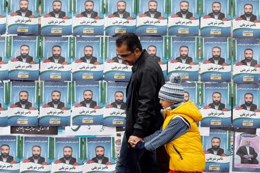 epa08227878 Iranians walk past electoral posters during the last day of election campaign, Tehran, Iran, 19 February 2020. Iranians will go to the polls to vote in the parliamentary elections on 21 February 2020.Â  EPA/ABEDIN TAHERKENAREH