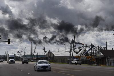 Vehicles drive past a petrol chemical plant near Highway 61 in Norco, Louisiana, on August 30, 2021 after Hurricane Ida made landfall. Patrick T.  Fallon / AFP)