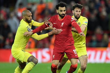 Liverpool's Egyptian midfielder Mohamed Salah (C) fights for the ball with Villarreal's French midfielder Etienne Capoue (L) and Villarreal's Spanish midfielder Manuel Trigueros during the UEFA Champions League semi-final first leg football match between Liverpool and Villarreal, at the Anfield Stadium, in Liverpool, on April 27, 2022.  (Photo by Oli SCARFF  /  AFP)