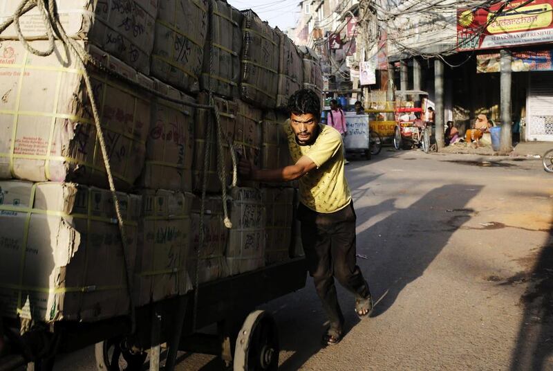 A labourer pushes a cart filled with goods through a street in Old Delhi, India. Anindito Mukherjee / Reuters