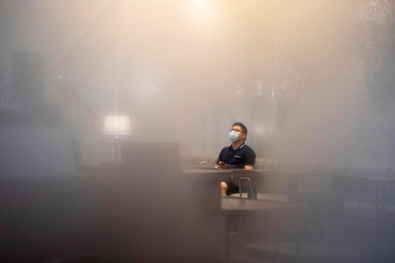 A man wearing a face mask sits in a cafe in a humid Guangzhou, Guangdong province, China.  EPA