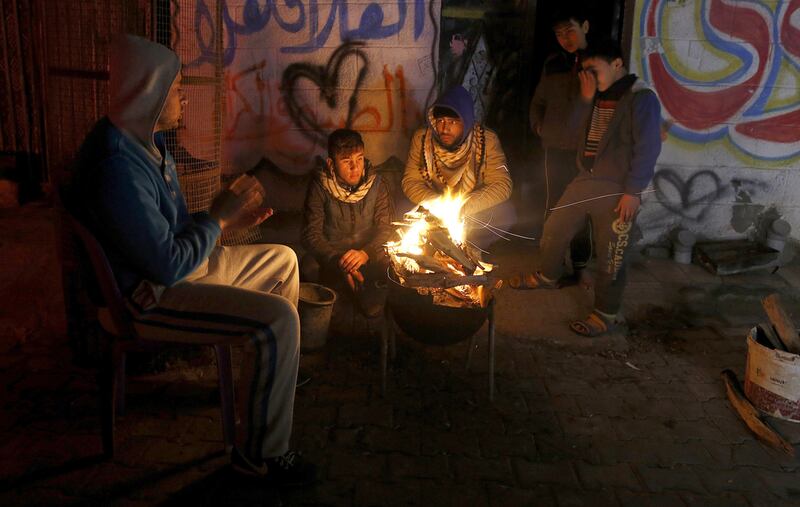 Palestinians, who get only several hours of electricity a day, sit around a fire outside their home in Gaza City. Israel said on April 27, 2017, that it was informed that the Palestinian self-rule government in the West Bank will stop paying for electricity Israel sells to the Gaza Strip. Hatem Moussa / AP Photo File