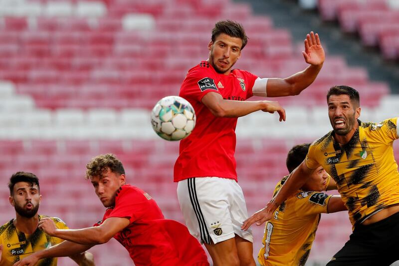Benfica's Ruben Dias, center, heads the ball to score the opening goal during the Portuguese League soccer match between Benfica and Moreirense at the Luz stadium in Lisbon, Saturday, Sept. 26, 2020. (AP Photo/Armando Franca)