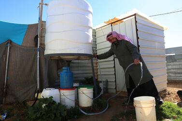 A Syrian man fills a bucket with water inside Zaatari, the largest camp for Syrian refugees in Mafraq, Jordan. Syrians benefit local economies, say the WFP. (AP)