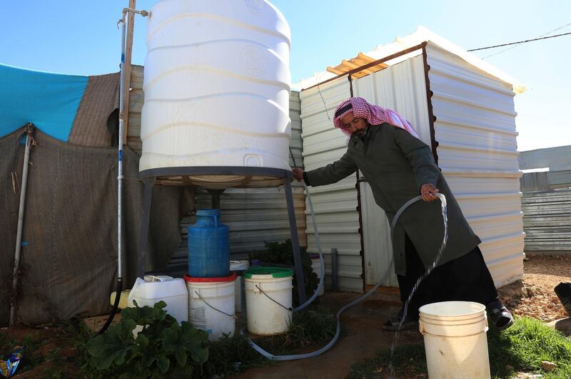 A Syrian man fills a bucket with water inside Zaatari, the largest camp for Syrian refugees in Mafraq, Jordan, Sunday, Feb. 3, 2019.  UNICEF says a project funded by Germany, Canada, UK and US, and led by Jordanian authorities, has connected all households in the sprawling camp to both water and sewage networks, making it the first such camp.(AP Photo/Raad Adayleh)