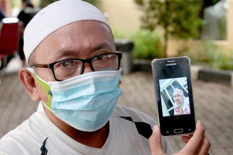 epa08932259 Habib Sy Rafik Al Idrus shows a picture of his wife, Panca Widia Nursanti, one of the victims of the crash of Sriwijaya Air flight SJ182 during a DNA (antimortem) test, at the police hospital in Jakarta, Indonesia, 12 January 2021. Contact to Sriwijaya Air flight SJ182 was lost on 09 January 2021 shortly after the aircraft took off from Jakarta International Airport while en route to Pontianak in West Kalimantan province. The plane crashed into the sea off the Jakarta coast.  EPA/Bagus Indahono