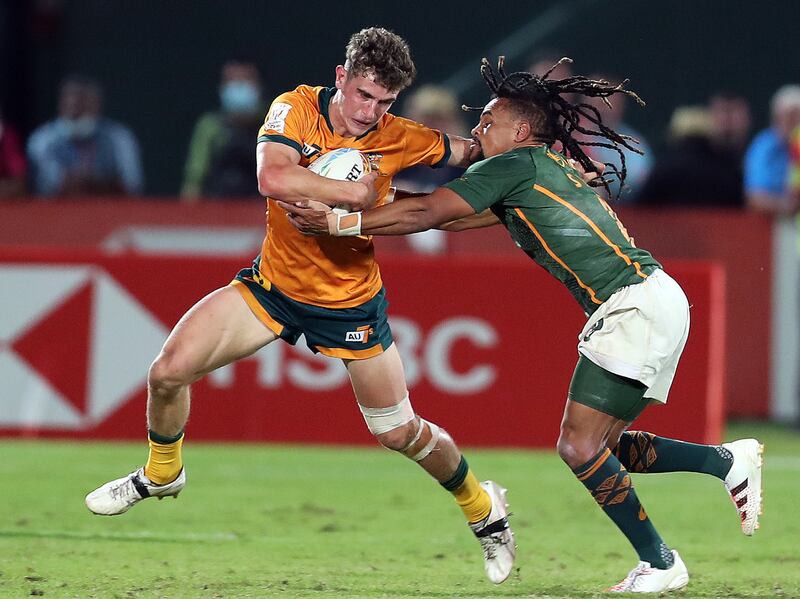 Australia's Ben Dowling attempts to hold off a tackle during the Dubai Sevens final against South Africa.