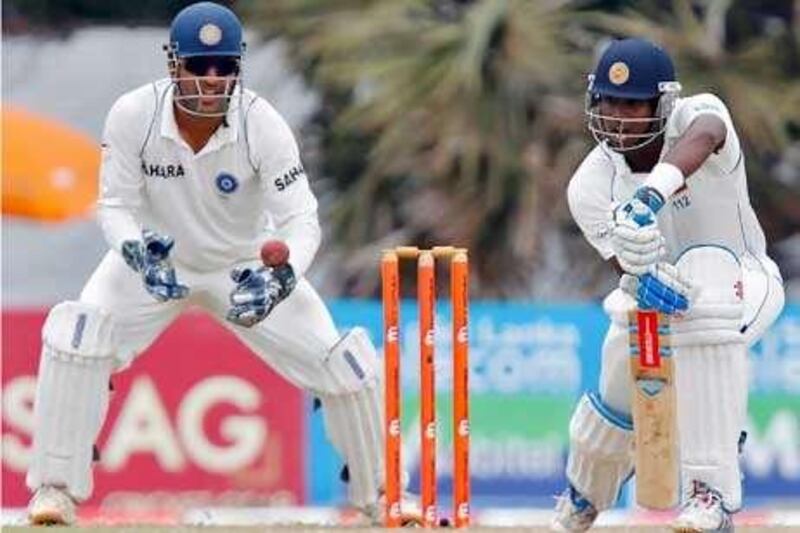 Sri Lanka's Angelo Mathews tries to push a spinning delivery down as India's captain and wicketkeeper Mahendra Singh Dhoni watches on in hope.