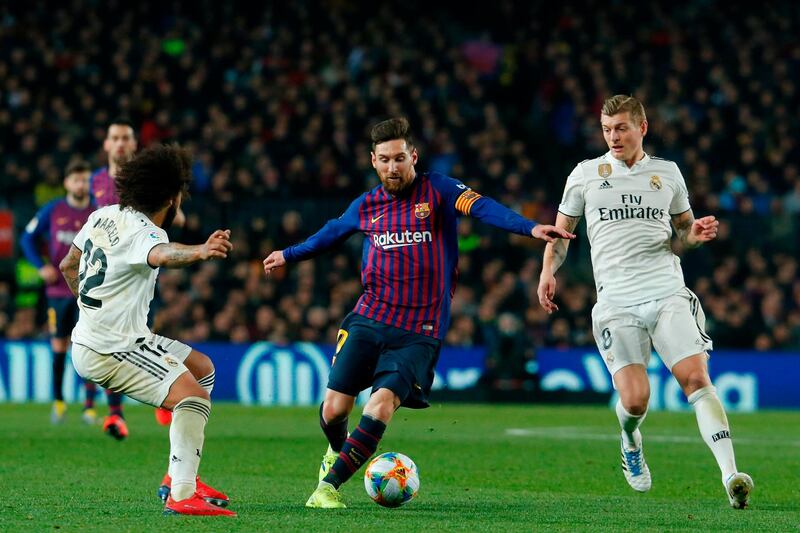 TOPSHOT - Barcelona's Argentinian forward Lionel Messi (C) vies for the ball with Real Madrid's Brazilian defender Marcelo (L) and Real Madrid's German midfielder Toni Kroos during the Spanish Copa del Rey (King's Cup) semi-final first leg football match between FC Barcelona and Real Madrid CF at the Camp Nou stadium in Barcelona on February 6, 2019. / AFP / Pau Barrena

