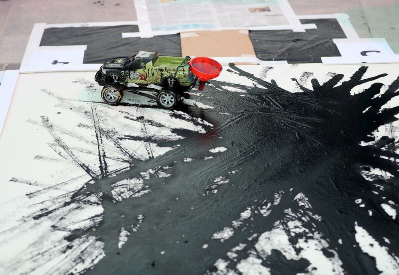 Dubai, United Arab Emirates - October 20, 2019: Artist Sharan Anil creates art using a remote control car at the One year to go celebrations. Sunday the 20th of October 2019. Burj Park, Dubai. Chris Whiteoak / The National
