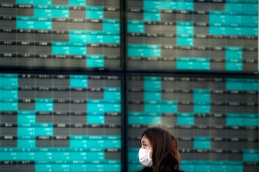 A woman stands of an electronic stock board showing Japan's Nikkei 225 index in Tokyo. Last week global stock markets crashed, as the 11-year bull market finally entered a new bear market. Associated Press