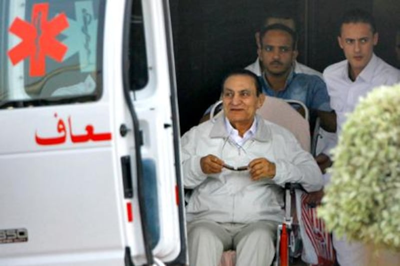 Former Egyptian President Hosni Mubarak, 85, is escorted by medical and security personnel into an ambulance to be taken by helicopter ambulance from Maadi Military Hospital to the Cairo Police Academy--turned--court, Cairo, Egypt, Sunday, Aug. 25, 2013. Mubarak, under house arrest after being released from detention last week, is standing retrial in charges of complicity in the killings of protesters during 2011 Egyptian uprising. (AP Photo/Amr Nabil)