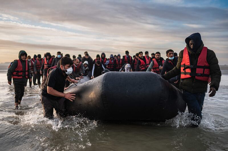 Migrants move a smuggling boat into the water near Dunkirk, northern France, before an attempt to cross the English Channel. AFP