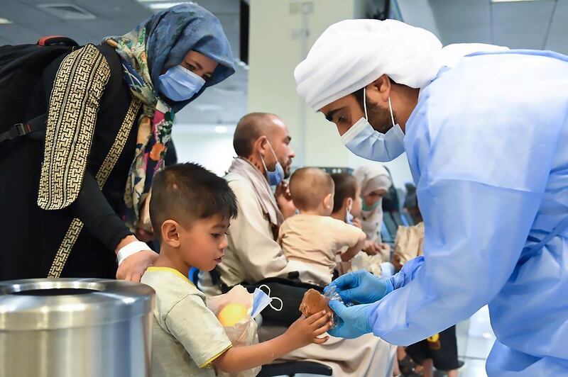 An Afghan boy is given food shortly after arriving at an accommodation centre in Abu Dhabi. Photo: Twitter/@AnwarGargash