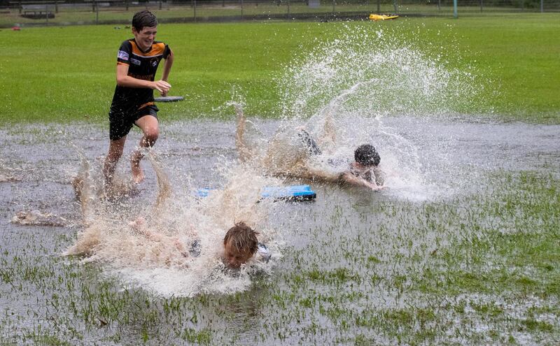 Children play in a flooded park in Port Stephens. AP
