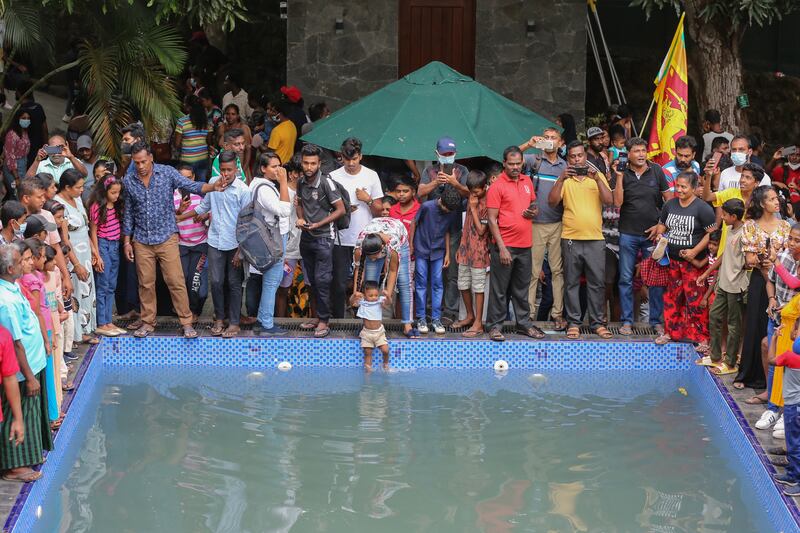 People take a dip in a swimming pool at the presidential palace in Colombo. EPA