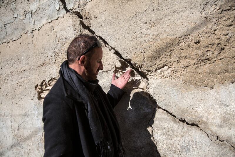 Jawad Siyam, a local activist with the Wadi Hilweh Information Center, points to some of the large cracks in the cement walls where he saidIsrael's tunnel digging had damaged more than 70 Palestinian homes in Wadi Hilweh, in Silwan ,displacing some residents. Israeli archeologists, backed by a right-wing nationalist Jewish organization, are digging a tunnel that they say traces a road Jewish worshippers used 2,000 years ago and now is set to be part of a larger tourist and religious attraction. 
(Photo by Heidi Levine for The National).