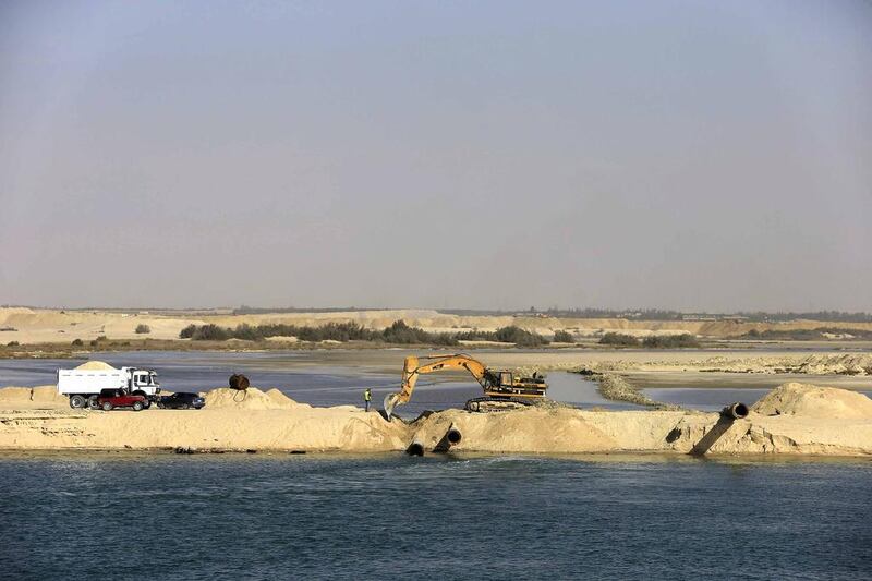 Bulldozers and trucks work on a new section of the New Suez Canal in Ismailia, Egypt. Hassan Ammar / AP Photo