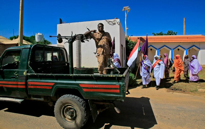 A Sudanese soldiers gestures as locals await the arrival of Sudan's prime minister in El-Fasher, the capital of the North Darfur state. AFP