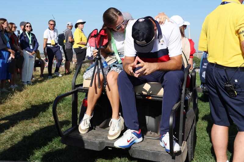 Scottie Scheffler of Team United States is consoled by his Wife, Meredith Scheffler after losing his match to Viktor Hovland and Ludvig Aberg of Team Europe 9&7 during the Saturday morning foursomes. Getty