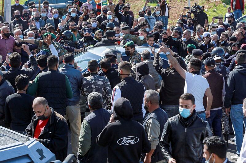 People stand on the side as Jordan's King Abdullah II arrives in his vehicle at a hospital in the town of Salt, northwest of the capital. AFP