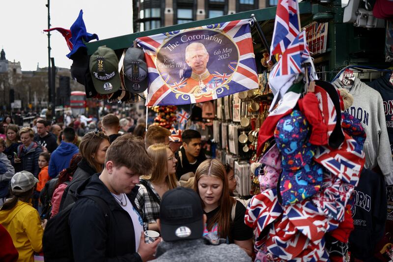 Shoppers browse souvenirs for the coronation of King Charles III outside the Houses of Parliament in London. Reuters