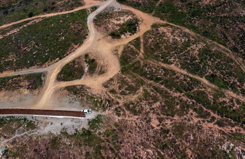 A Border Patrol unit remains next to a section of the US-Mexico border fence at El Nido de las Aguilas, eastern Tijuana, Baja California state. AFP