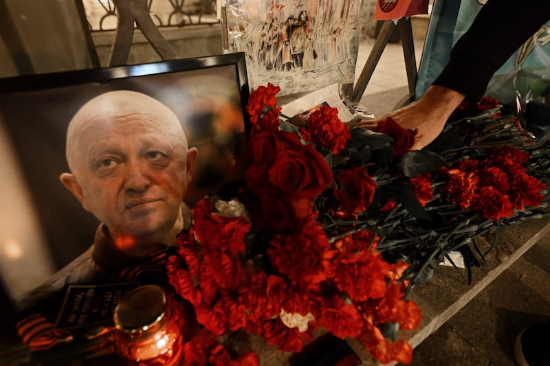 A man lays flowers at the makeshift memorial in Russia in honour of Yevgeny Prigozhin. AFP