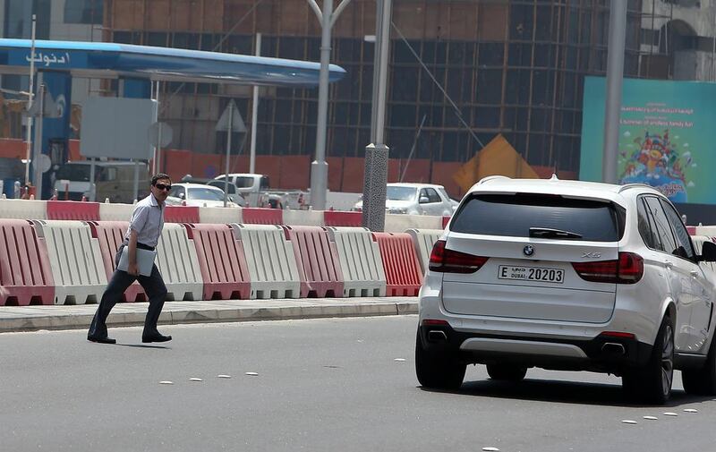 A man crosses Sheikh Zayed Street, through public work barricades. Twenty-six people were counted doing the same in 30 minutes. Pawan Singh / The National