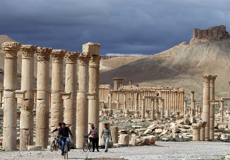 A picture taken on March 14, 2014 shows Syrian citizens riding their bicycles the ancient oasis city of Palmyra, 215 kilometres northeast of Damascus. From the 1st to the 2nd century, the art and architecture of Palmyra, standing at the crossroads of several civilizations, married Graeco-Roman techniques with local traditions and Persian influences. AFP PHOTO/JOSEPH EID / AFP PHOTO / JOSEPH EID