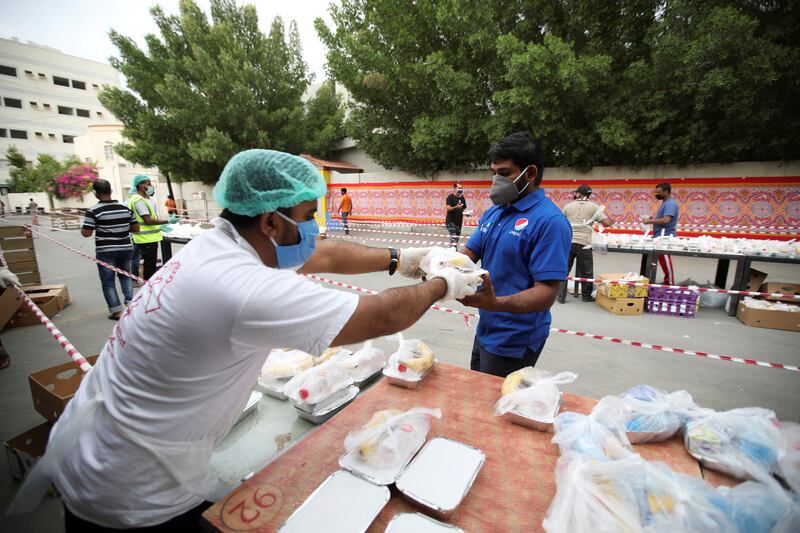 Volunteers wearing protective face masks and gloves hand out Iftar meals provided by the authorities, following the outbreak of the coronavirus disease (COVID-19), during the holy month of Ramadan, in Manama, Bahrain, May 6, 2020. REUTERS/Hamad I Mohammed
