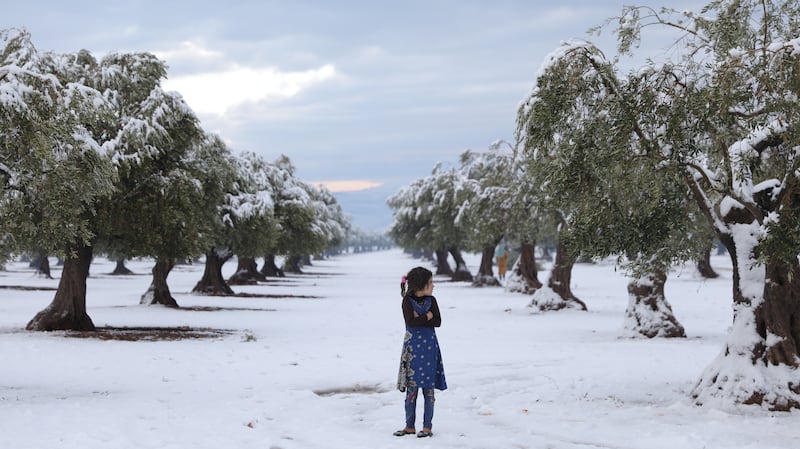 An internally displaced child explores the snowy landscape