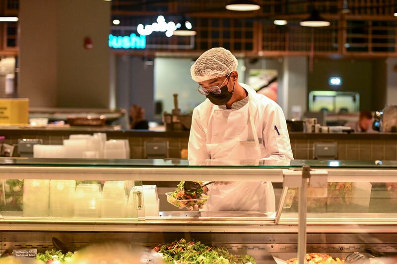 A worker serves salad at Lulu Hypermarket, Abu Dhabi. Khushnum Bhandari / The National