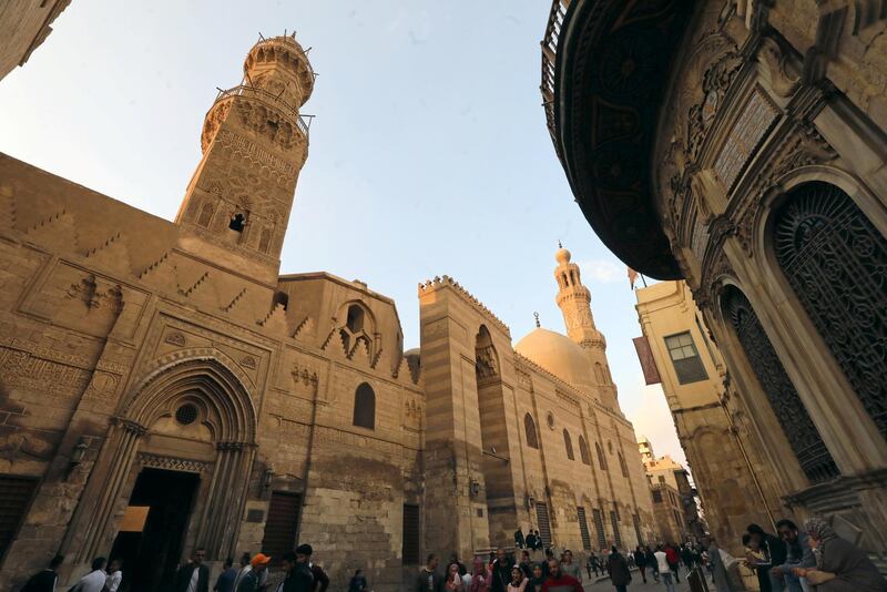 People walk in front of mosques and Islamic schools at El Moez Ledin Allah El Fatmy Street, in old Islamic Cairo, Egypt December 30, 2018. REUTERS/Mohamed Abd El Ghany