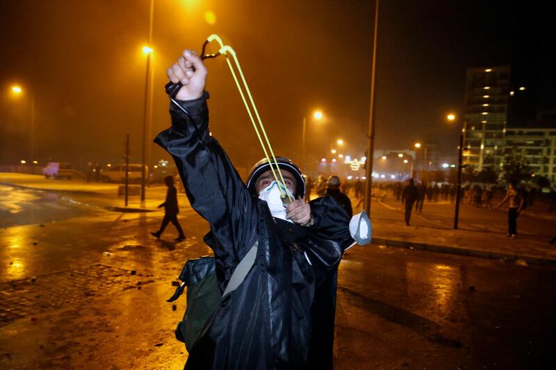 An anti-government demonstrator uses a slingshot against the Lebanese riot police in Beirut.  AP Photo
